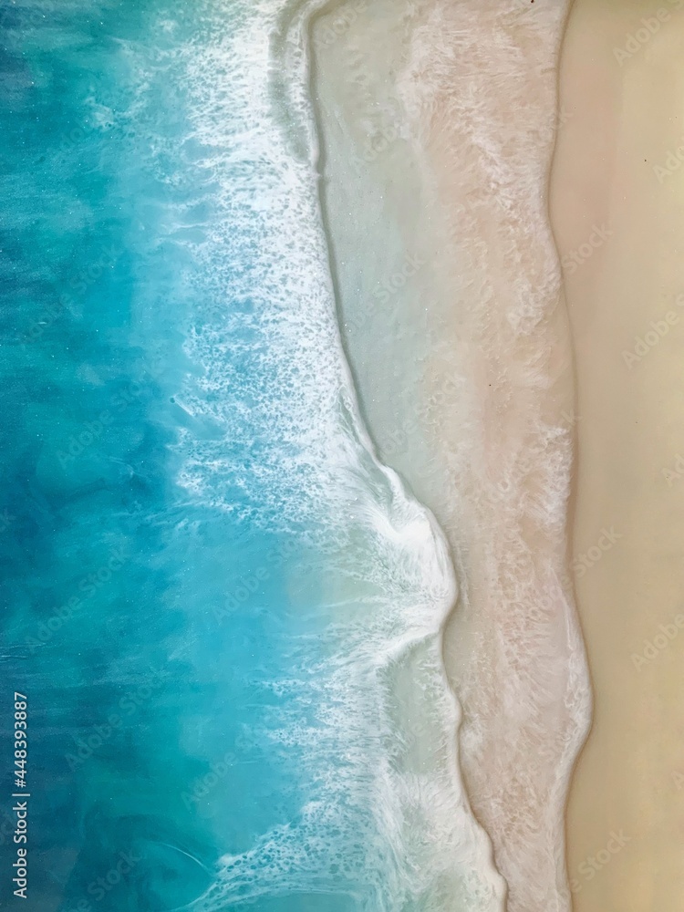 Top view on sea wave with white foam and light beige sand. Fluid, pour drawing of epoxy resin. Summer sunny beach painting, seascape, blue, azure, turquoise color of water, shore. 