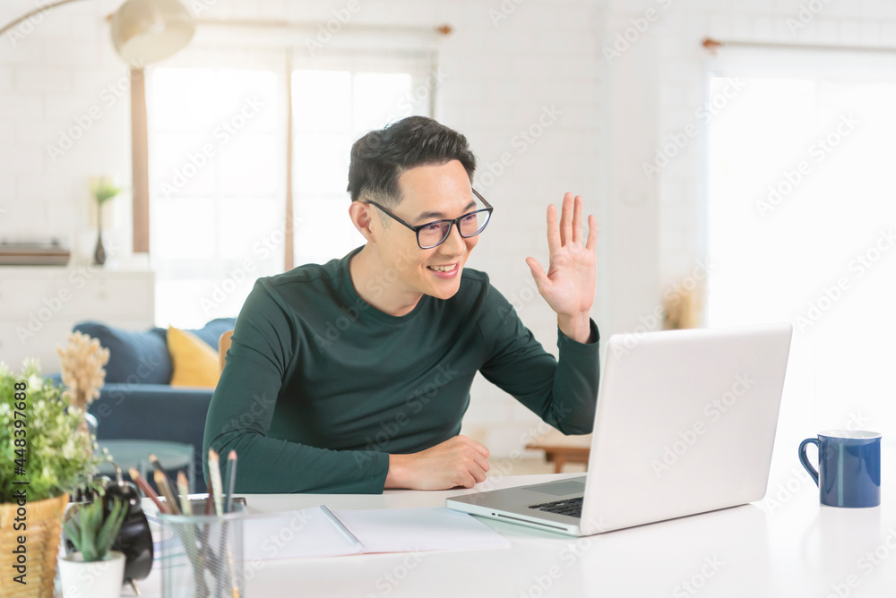 Smiling handsome asian businessman working remotely from home. He is webinar video conference. Smiling handsome asian businessman working remotely from home. He is webinar video conference.