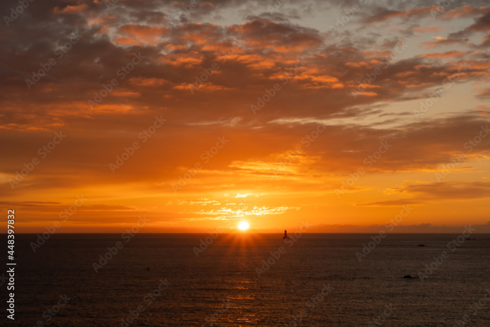 einzigartiger Sonnenuntergang über dem atlantischen Ozean vor der Küste von Porspoder mit dem Leuchtturm der vier (Phare du Four), Bretagne, Frankreich