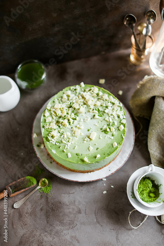Layered cake with white chocolate and matcha tea. Mousse dessert in a light dish on a dark table.
