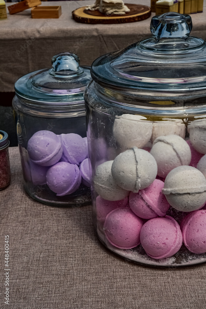 large glass jars filled with artisan made bath bombs in pastel colors on  display table at farmer's market Stock Photo | Adobe Stock