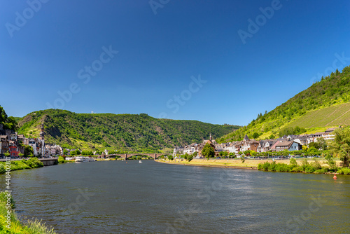 Cochem, Germany, June 13, 2021. Beautiful view of the colorful buildings along the river with a bridge and the old town of Cochem on the Moselle river in Rhineland-Palatinate, Germany.