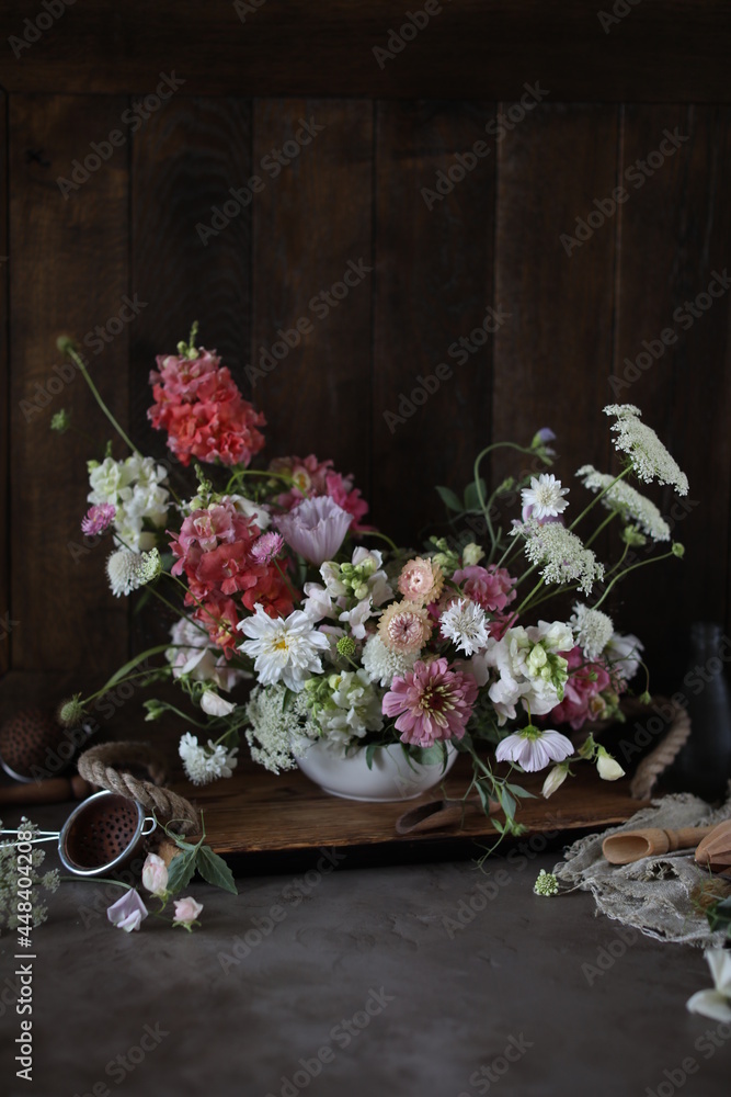 Fototapeta premium Floral arrangement of summer garden flowers in pastel shades on the table. English floristry. Still life.
