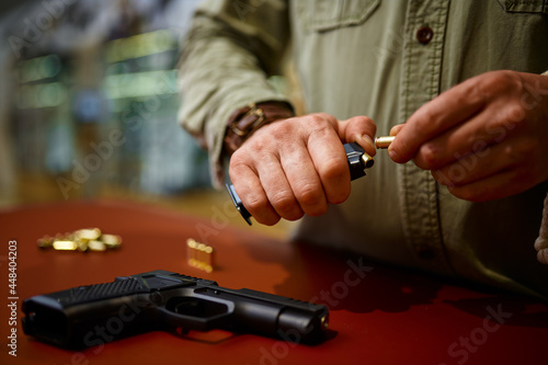 Man loads the magazine with bullets in gun store