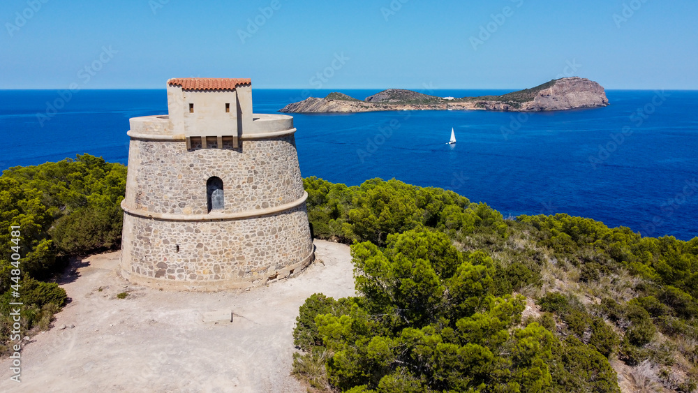 Torre den Valls, aka Torre de Campanitx, a defensive round tower at the easternmost point of Ibiza in the Balearic Islands, Spain - Stone fortress with a view on the island of Tagomago