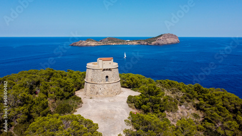 Torre den Valls, aka Torre de Campanitx, a defensive round tower at the easternmost point of Ibiza in the Balearic Islands, Spain - Stone fortress with a view on the island of Tagomago photo