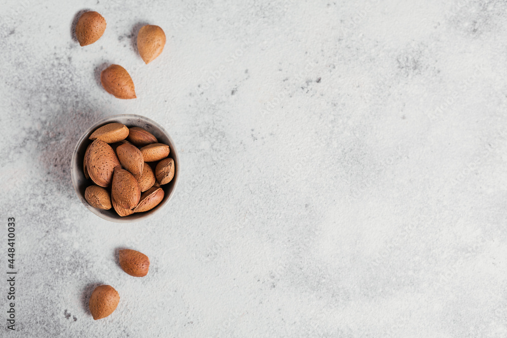 Pile of Almond nuts in a bowl on a white background. Fresh nuts in their shells. Pile of Almond nuts in a bowl on a white background. Fresh nuts in their shells.