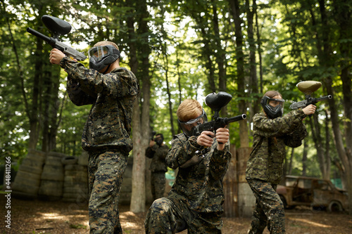 Foto Soldiers in camouflage and masks playing paintball