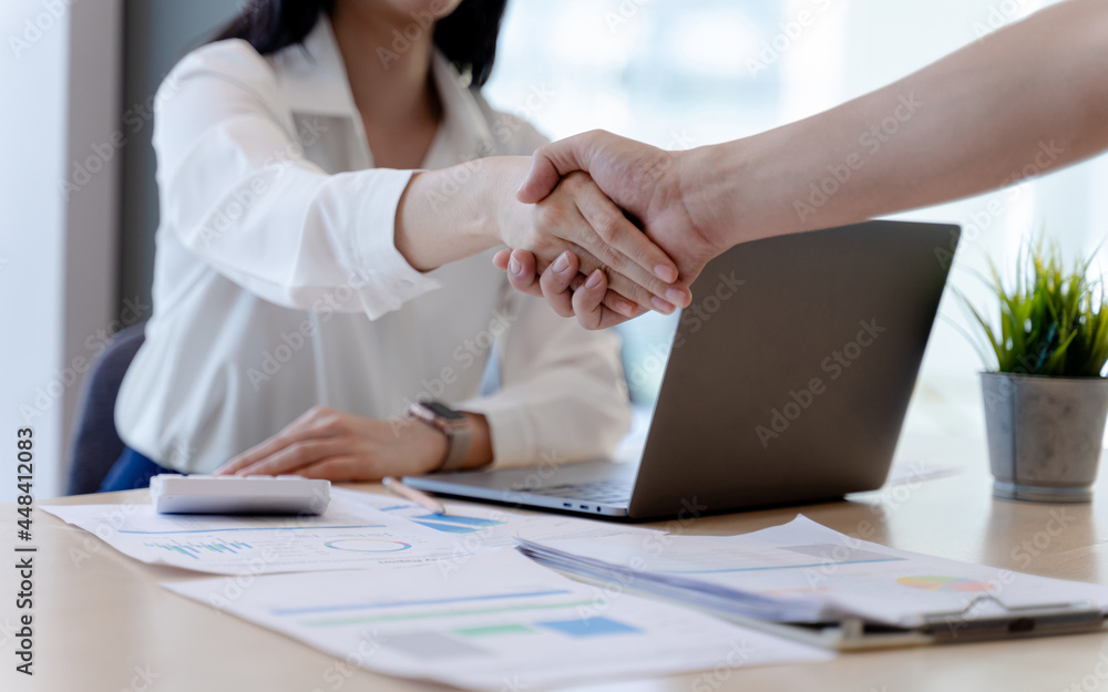 Businesswoman or bank officer Shaking hands after agreeing to work together successfully in office. Concept of Professional executive partners working at the workplace. Businesswoman or bank officer Shaking hands after agreeing to work together successfully in office. Concept of Professional executive partners working at the workplace.