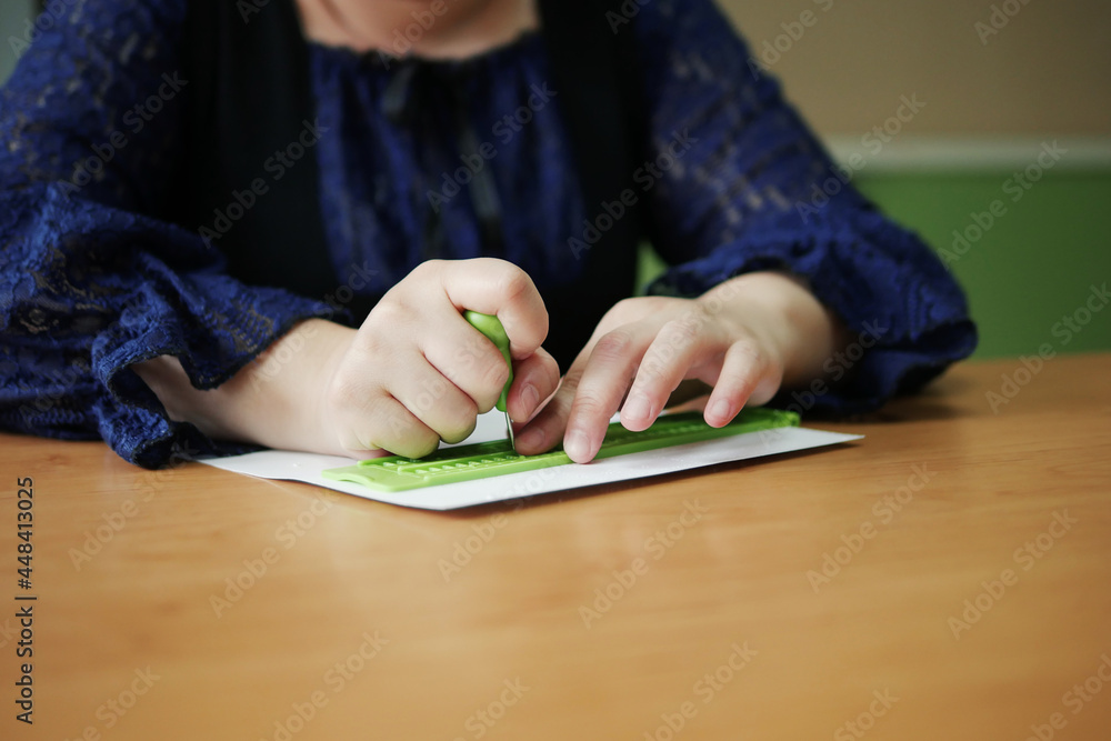Closeup of disability blind person woman hands writing braille text on