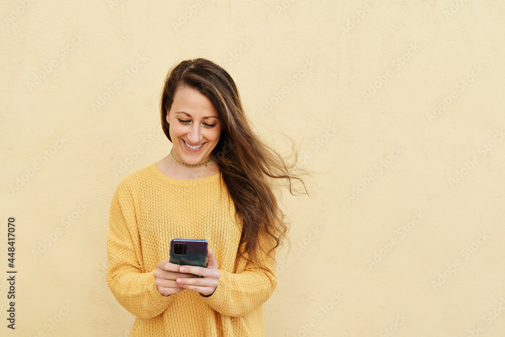 blonde woman with long hair and smiling while chatting on her smart phone. blonde woman with long hair and smiling while chatting on her smart phone.
