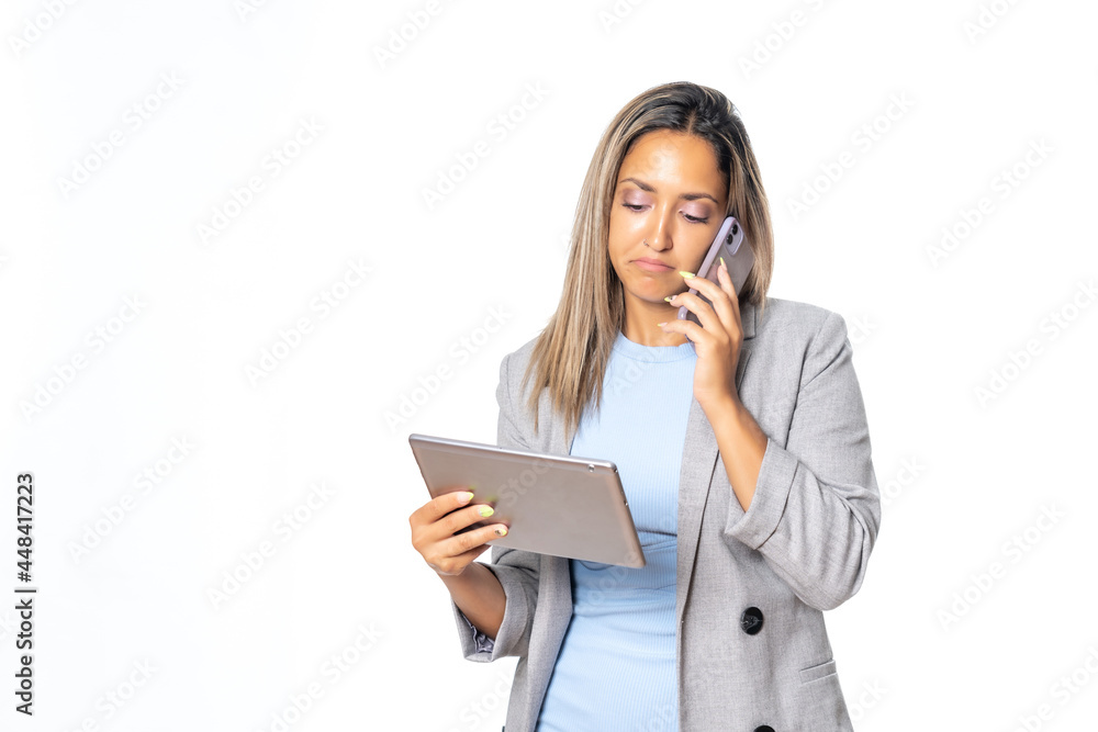 Mujer joven y bella hablando por el móvil y consultando la tablet Mujer joven y bella hablando por el móvil y consultando la tablet