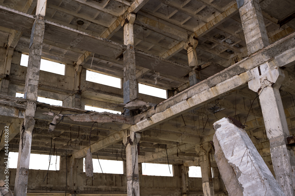 The frame of the building is a close-up with concrete beams with a pile in the foreground. The frame of the building is a close-up with concrete beams with a pile in the foreground.