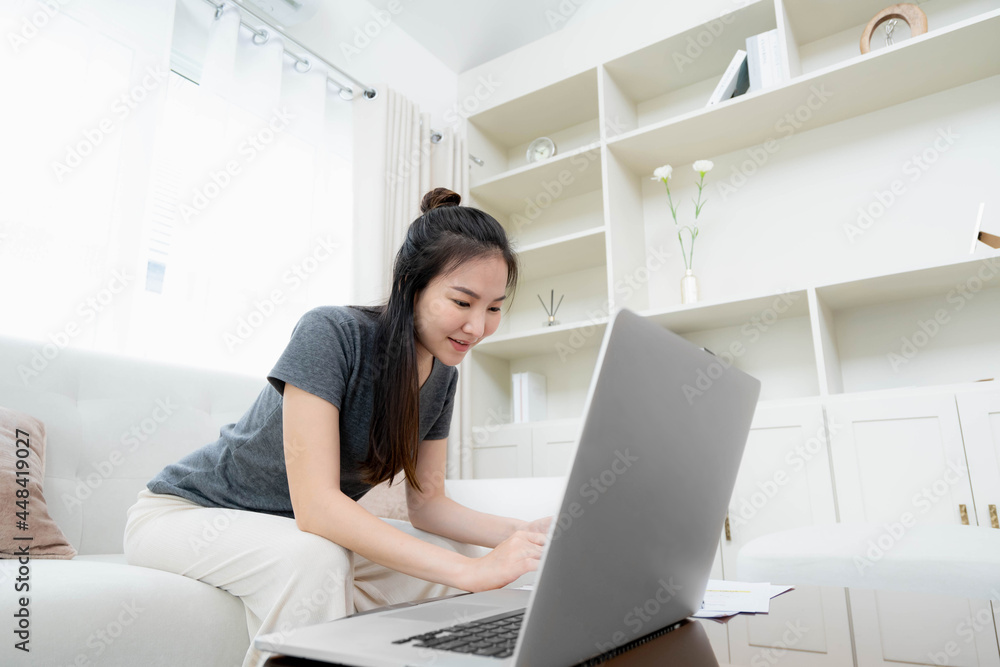 happy Young asian woman working with laptop in bed at home in the morning. happy Young asian woman working with laptop in bed at home in the morning.