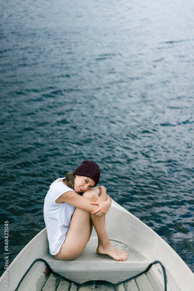 Chica joven y bonita sola en una barca, un momento mindfullness, de calma de paz interior.