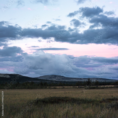 paisaje de nubes y montaña con cielo rosado y azul en Noruega.