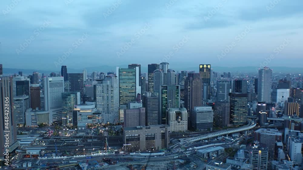 UMEDA, OSAKA, JAPAN : Aerial high angle sunset view of CITYSCAPE of OSAKA. View of buildings and street around Osaka and Umeda station. Wide view time lapse shot, dusk to night. UMEDA, OSAKA, JAPAN : Aerial high angle sunset view of CITYSCAPE of OSAKA. View of buildings and street around Osaka and Umeda station. Wide view time lapse shot, dusk to night.
