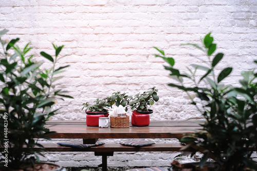Fototapeta Naklejka Na Ścianę i Meble -  wooden table and chairs on a background of a white brick wall in a cafe. summer terrace of the restaurant mockup 