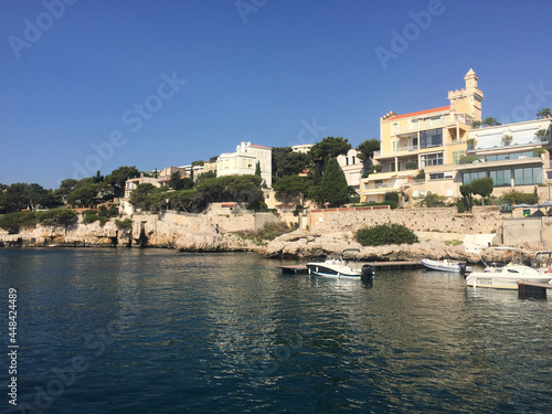 The coastline and residential buildings along the entrance to Cassis Harbour on a summer sunny day, located in the Provence-Alpes-Côte d'Azur region, on the French Riviera in Southern France. 