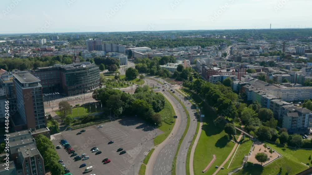 High angle view of city in flat coastal landscape. Panning of various buildings and main multi lane road in town High angle view of city in flat coastal landscape. Panning of various buildings and main multi lane road in town