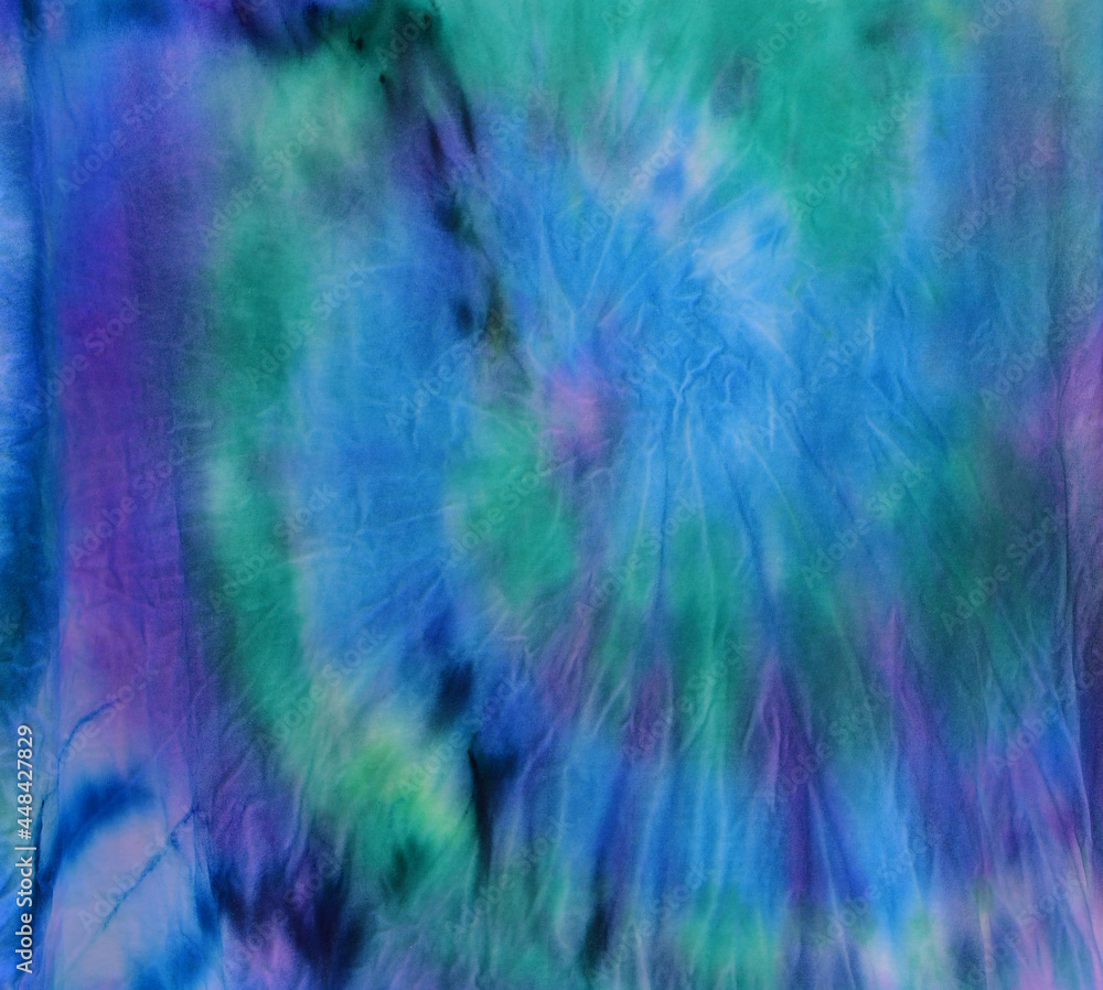 Abstract painted background. Multi-colored pattern in the shibori technique on a thin knitted fabric. Multi-color texture. Batik.Textile shibori Abstract painted background. Multi-colored pattern in the shibori technique on a thin knitted fabric. Multi-color texture. Batik.Textile shibori