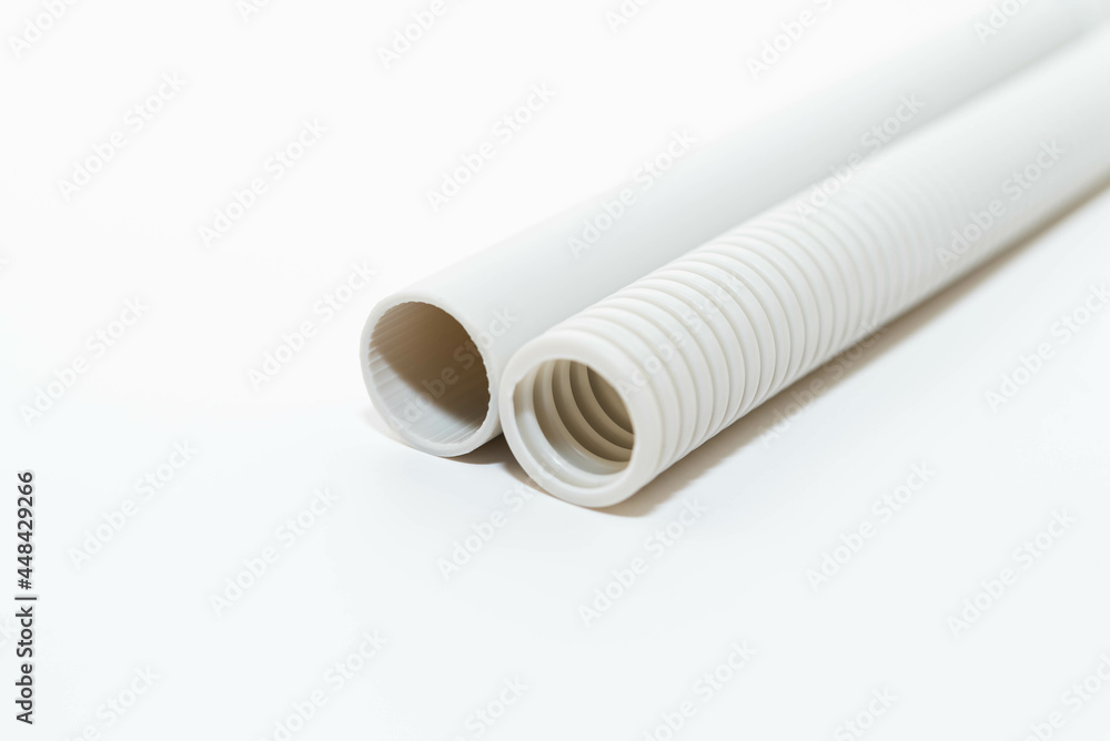 PVC rigid and flexible electrical conduit isolated on white background. Plastic curvilinear hoses. White corrugated pipe for installation of electrical cable PVC rigid and flexible electrical conduit isolated on white background. Plastic curvilinear hoses. White corrugated pipe for installation of electrical cable