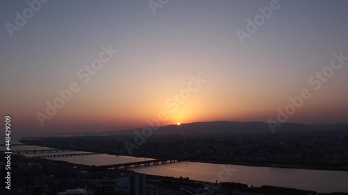 OSAKA, JAPAN : Aerial high angle sunset view of CITYSCAPE of OSAKA. Wide view time lapse shot, dusk to night. View of buildings and street traffic around Yodogawa river. photo