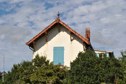 Gable on Old French Farmhouse Building against Cloudy Blue Sky  © eyepals