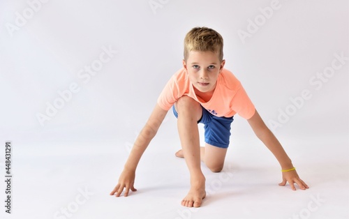 boy sits at the start to the run on a white background