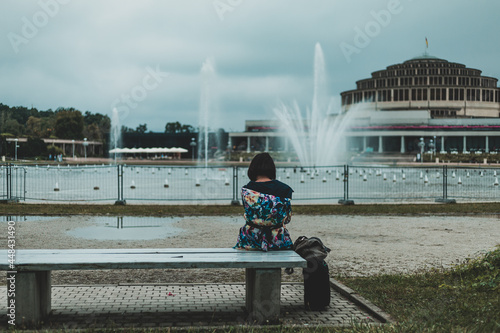 woman sitting on the bench, Centennial Hall in the background photo