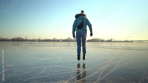 Adult caucasian woman in blue jacket and light jeans skates