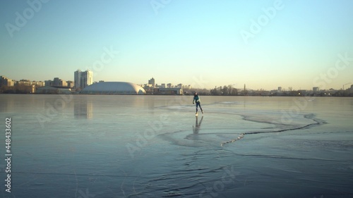 Adult caucasian woman skater skating in winter on ice of frozen lake