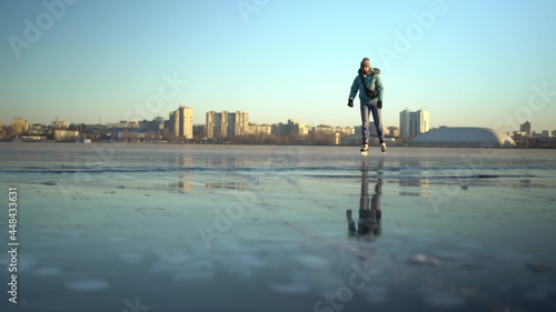 Adult caucasian woman skater skating in winter on ice of frozen lake