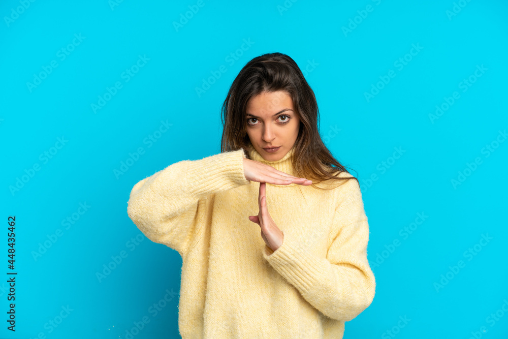 Young caucasian woman isolated on blue background making time out gesture Young caucasian woman isolated on blue background making time out gesture