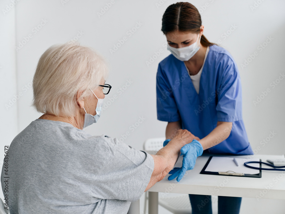 Nurse giving an injection to an elderly patient in the office safety covid passport Nurse giving an injection to an elderly patient in the office safety covid passport