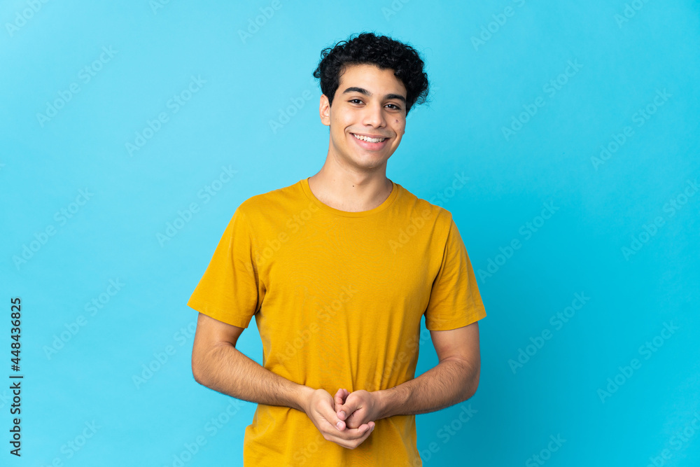 Young Venezuelan man isolated on blue background laughing Young Venezuelan man isolated on blue background laughing