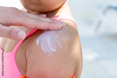 Applying sunscreen cream to the face of a small child, sun and ultraviolet protection