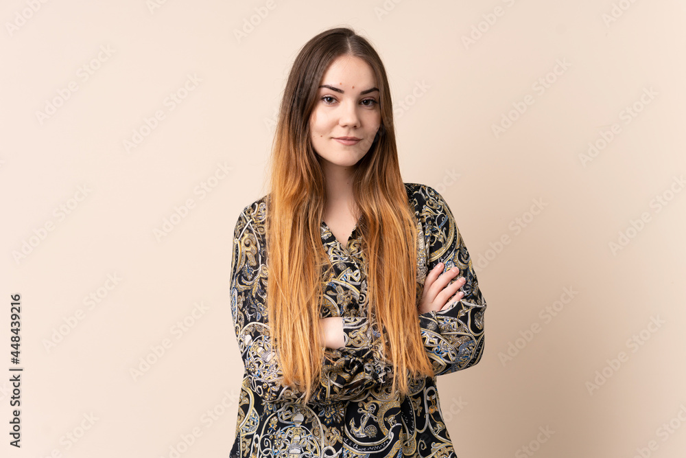 Young caucasian woman isolated on beige background keeping the arms crossed in frontal position Young caucasian woman isolated on beige background keeping the arms crossed in frontal position
