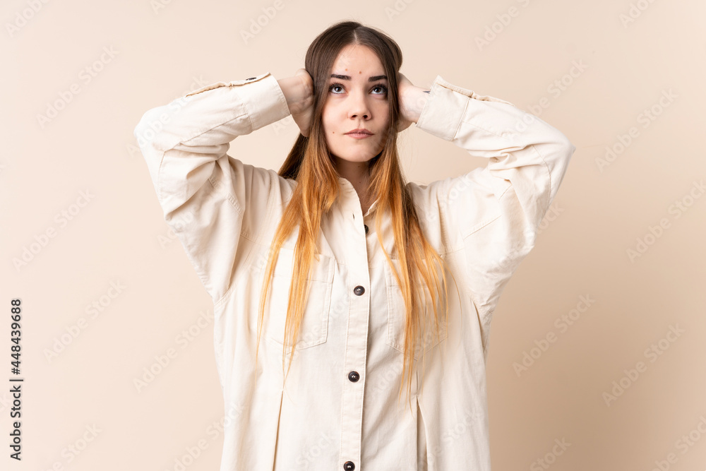Young caucasian woman isolated on beige background frustrated and covering ears Young caucasian woman isolated on beige background frustrated and covering ears