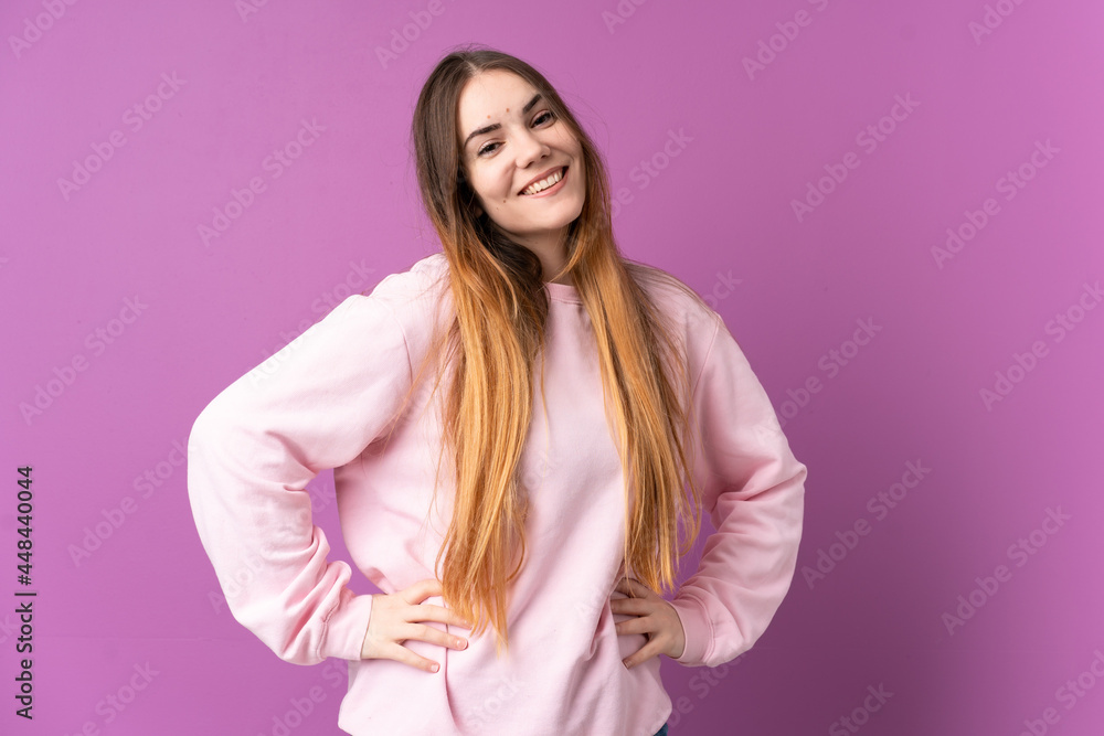 Young caucasian woman isolated on purple background posing with arms at hip and smiling Young caucasian woman isolated on purple background posing with arms at hip and smiling