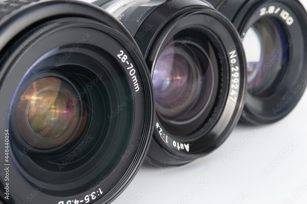 Modern and old DSLR camera lens set on white background close-up