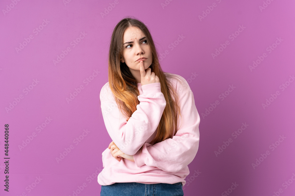 Young caucasian woman isolated on purple background having doubts while looking up Young caucasian woman isolated on purple background having doubts while looking up