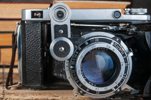 vintage folding film camera on wood background close-up