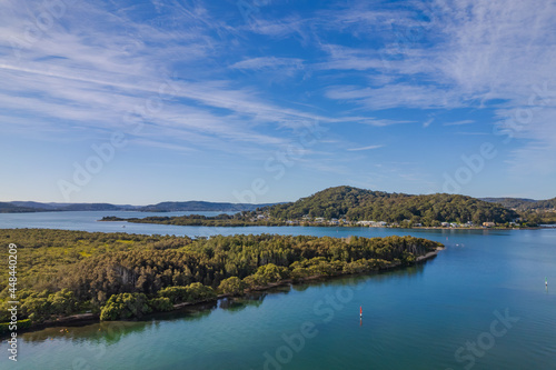 Afternoon aerial waterscape over the bay with boats and high cloud