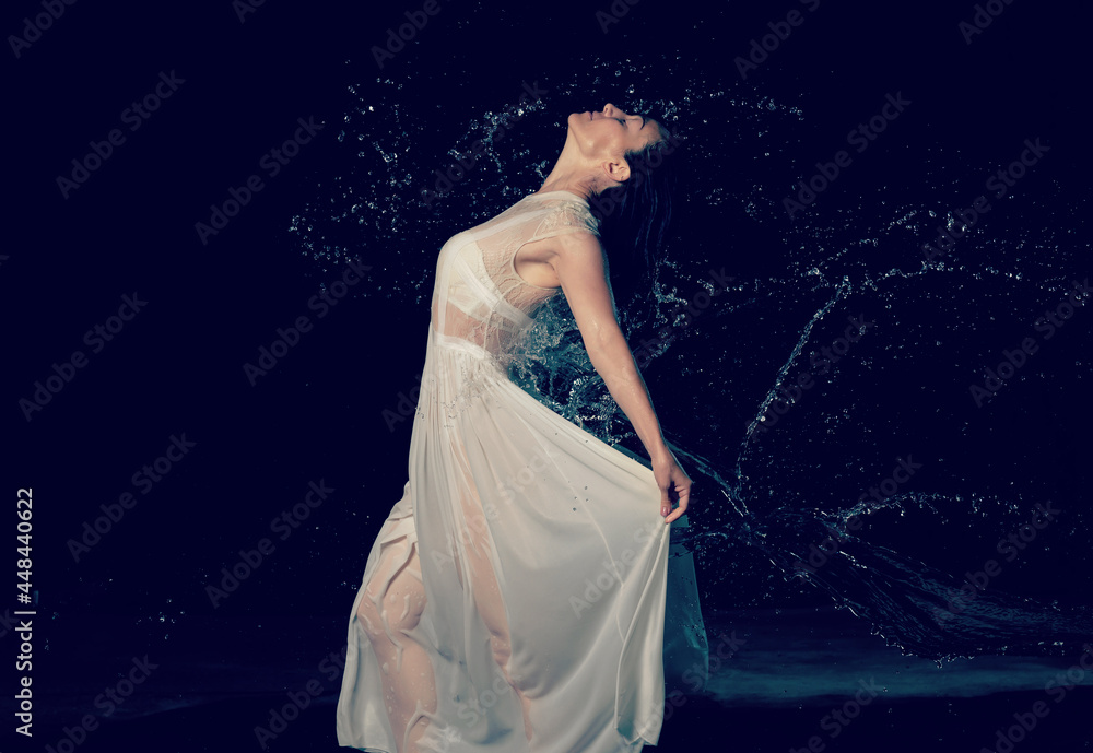 beautiful woman of Caucasian appearance with black hair dances in drops of water on a black background beautiful woman of Caucasian appearance with black hair dances in drops of water on a black background