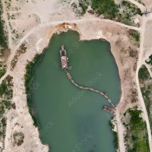 Aerial view on a sand quarry with an industrial ship in the pond