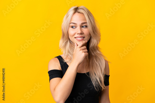 Young Russian woman isolated on yellow background looking to the side and smiling