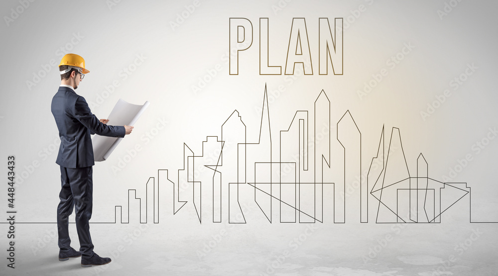 Businessman in hard hat holding blueprint Businessman in hard hat holding blueprint
