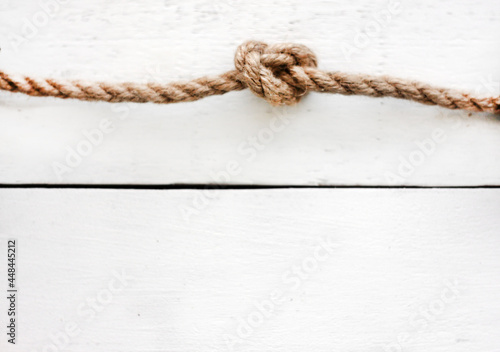 Rope knot on a white wooden background