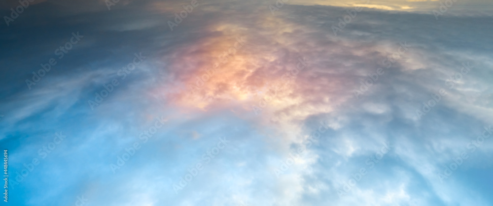 Dense, henday clouds at sunset. Natural colorful sunlights. Natural evening sunset and thick blue clouds. View of the cloudy sky from space